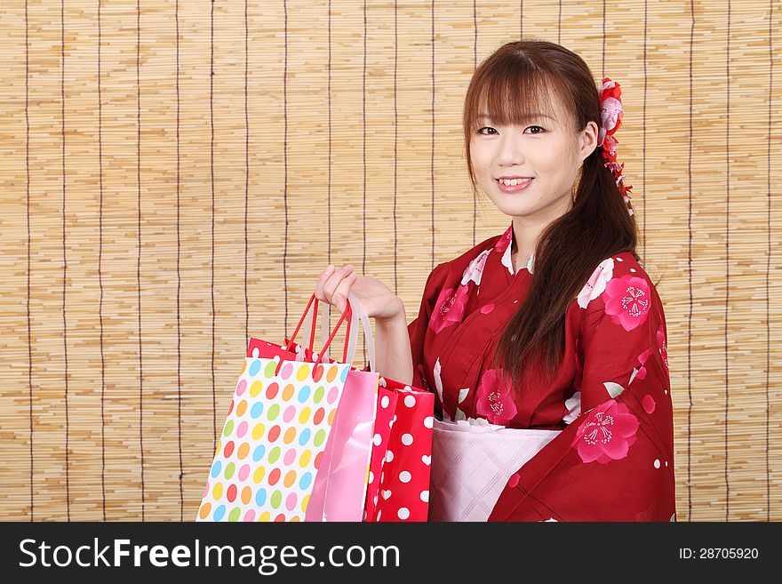 Young asian woman in traditional clothes of kimono with shopping bags. Young asian woman in traditional clothes of kimono with shopping bags