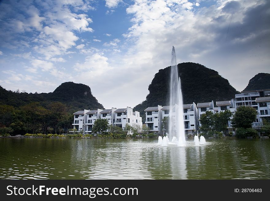 Fountain in lake of modern house with blue sky and cloud