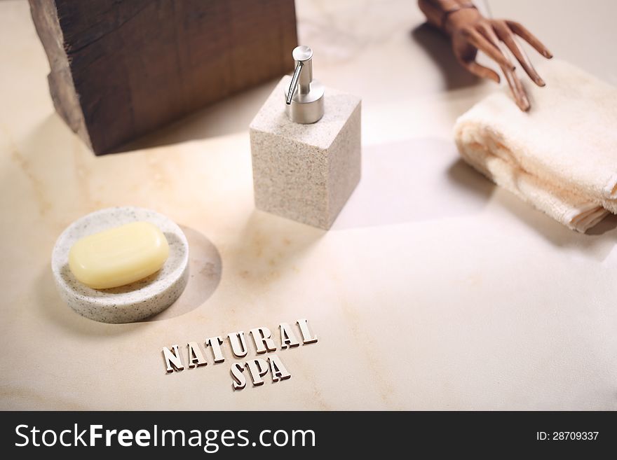 Natural spa. Soap and bottle on the beige background. Woody hand on the towel.