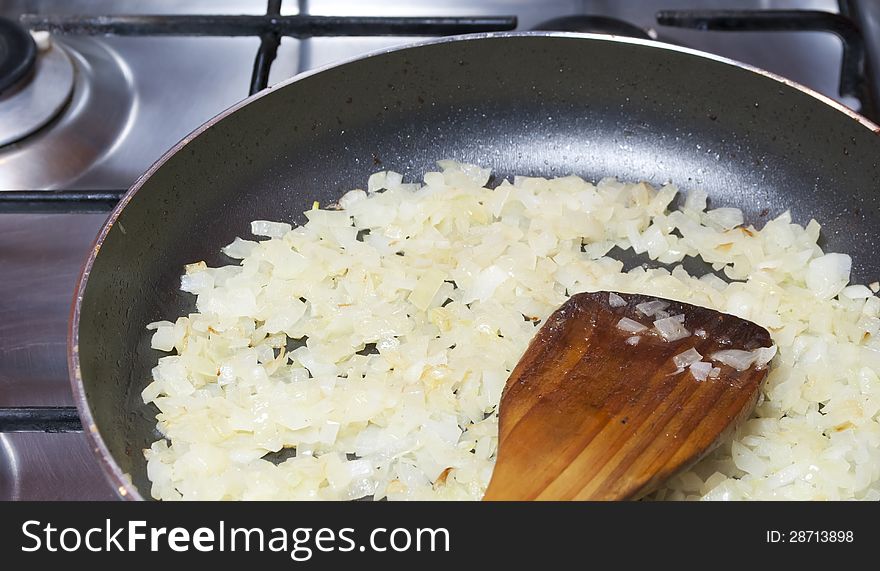 Sliced onion fried in a pan