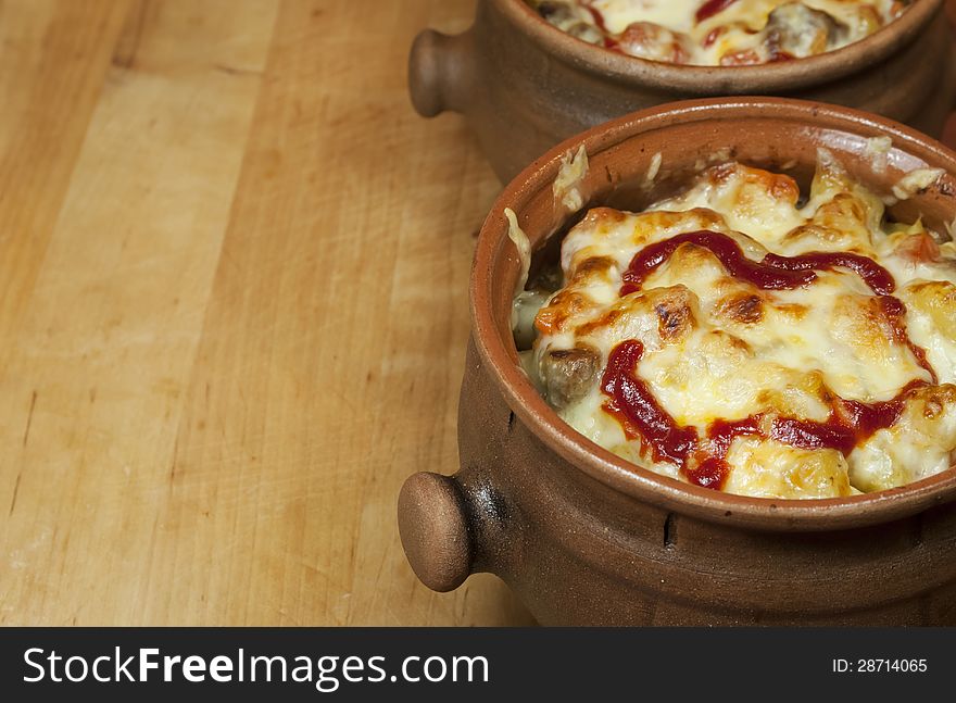 Meat and vegetables with cheese and ketchup  in pots