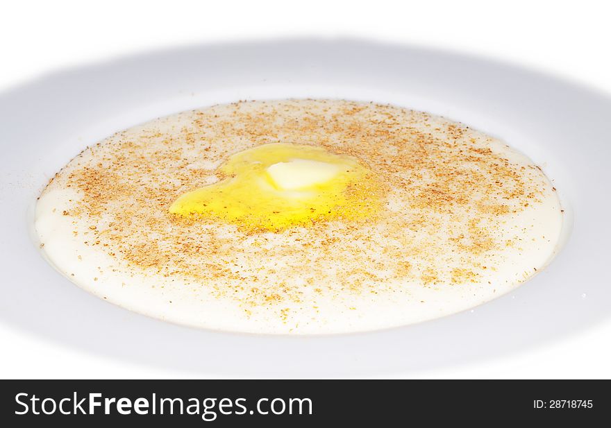 Porridge in a deep bowl with butter eye, cinnamon and sugar