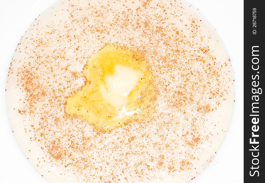 Porridge in a deep bowl with butter eye, cinnamon and sugar