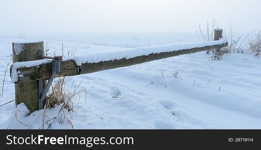 Wooden barrier over snowy road with dense fog in background. Wooden barrier over snowy road with dense fog in background