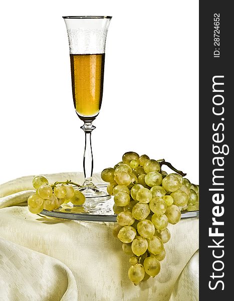 Bunch of grapes on a glass plate and a glass of white wine. Bunch of grapes on a glass plate and a glass of white wine