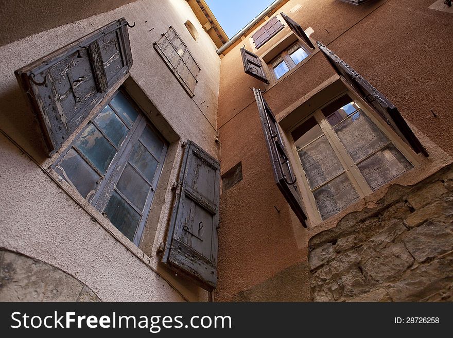 Two orange plastered walls in an angle covered with shutters, shot from a low angle. Two orange plastered walls in an angle covered with shutters, shot from a low angle.