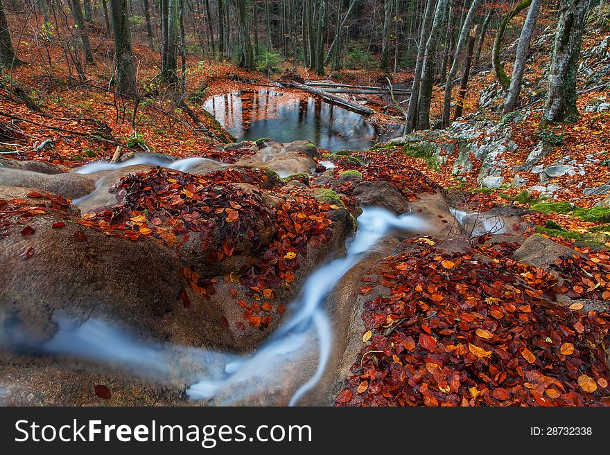 Beautiful autumn foliage, waterfalls and reflection patterns in mountain stream in the forest. Beautiful autumn foliage, waterfalls and reflection patterns in mountain stream in the forest