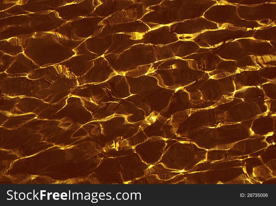 Background made ??ripples on the water golden yellow color. Background made ??ripples on the water golden yellow color