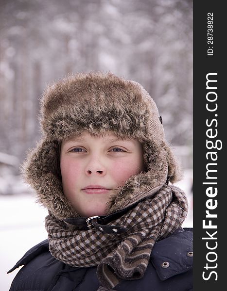 The boy looking dreamily into the distance.Snowy forest in the cold winter. The boy looking dreamily into the distance.Snowy forest in the cold winter