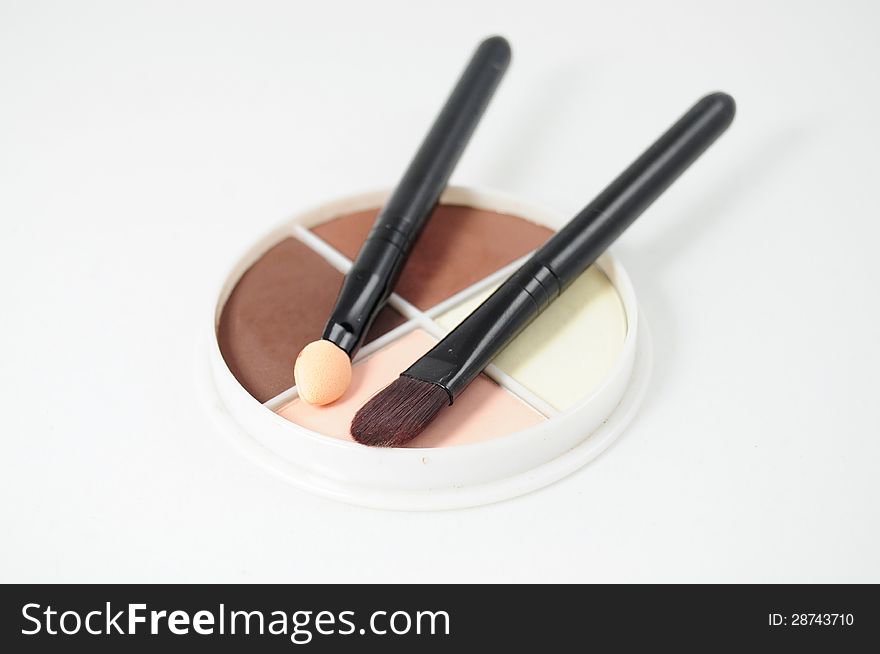 Set of four eyeshadows and makeup brushes on white background. Set of four eyeshadows and makeup brushes on white background