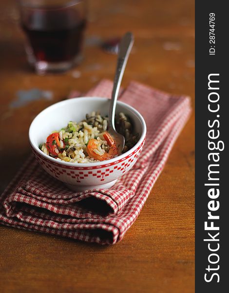 Cooked brown rice with celery, tomatoes and shrimps in a bowl