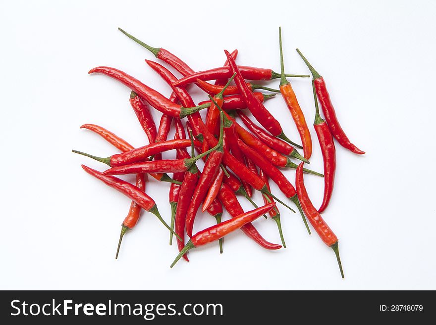 A pile of red chilli  on white background. A pile of red chilli  on white background.