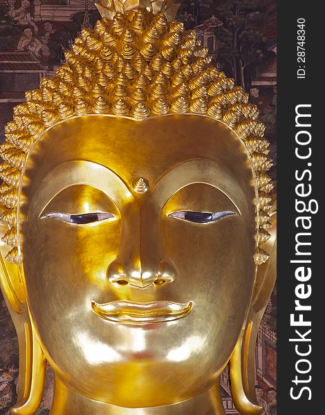 Golden Buddha face in Bangkok Thailand showing calm and mercy.