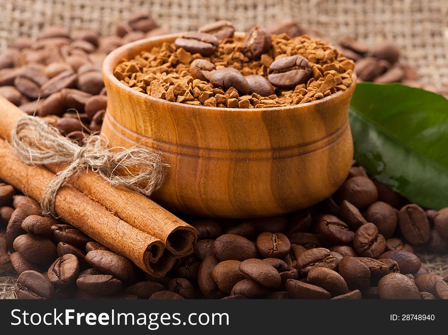 Coffee beans in a wooden bowl on burlap background