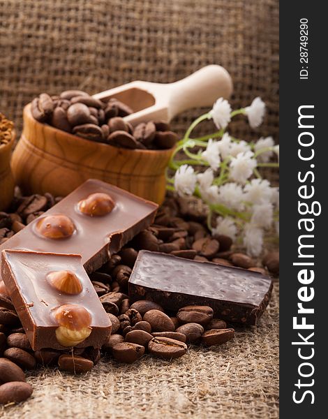 Coffee beans in a wooden bowl on burlap background