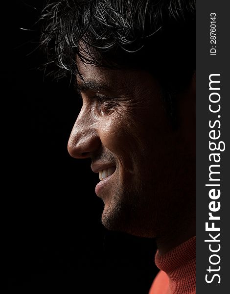 Grains & textures are added in the portrait of Indian man smiling over dark background. Grains & textures are added in the portrait of Indian man smiling over dark background