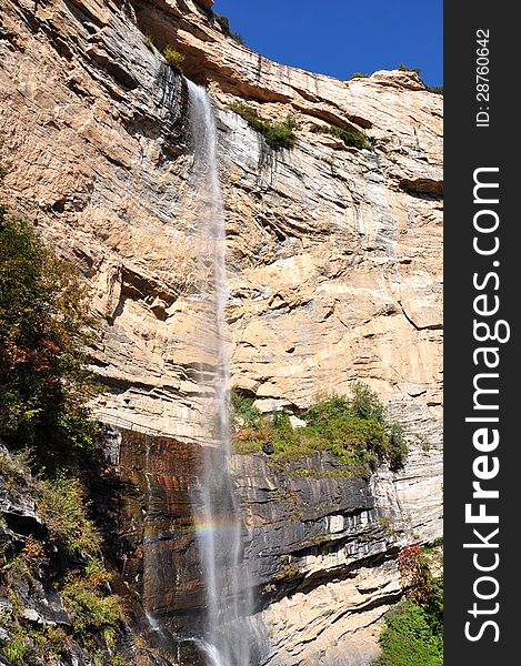 Falling waterfall with sun intertwined, and launched into a rainbow