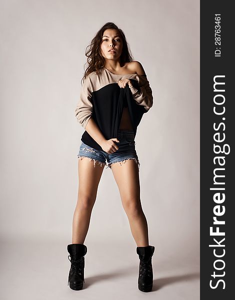Beautiful girl in denim shorts posing in studio shot