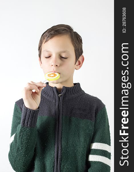 Schoolboy with lollipop over white wall,it is not isolated