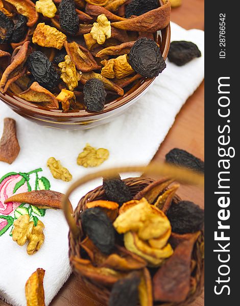 Dried fruits and nuts in bowl and basket on table. Dried fruits and nuts in bowl and basket on table.