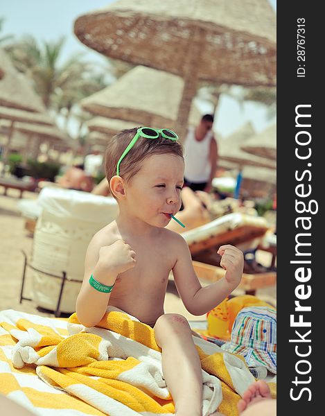 After bathing cheerful child sitting under a canopy in the towel. After bathing cheerful child sitting under a canopy in the towel