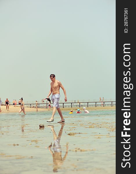 On a beach the guy goes on water during outflow. On a beach the guy goes on water during outflow