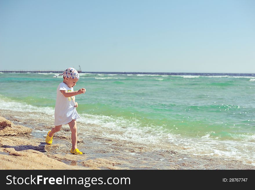 The child on the sea in a hat has a rest in the summer. The child on the sea in a hat has a rest in the summer