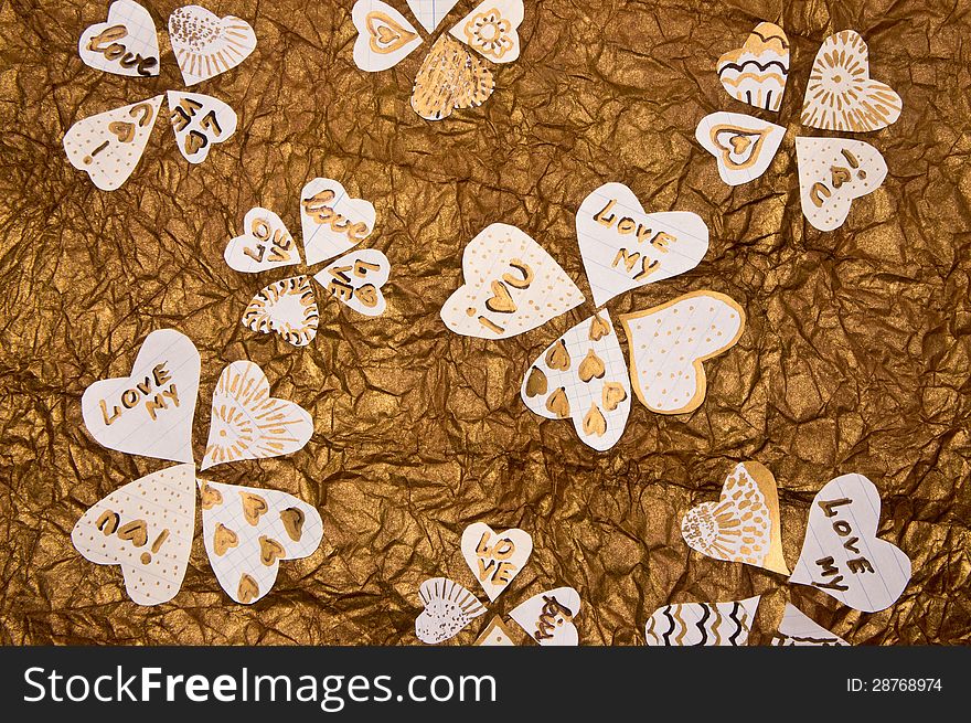 Handmade hearts on a background of golden-brown textured paper. Handmade hearts on a background of golden-brown textured paper