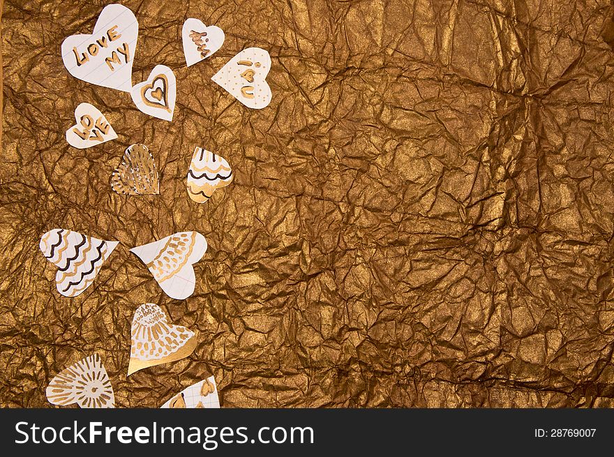 Handmade hearts on a background of golden-brown textured paper. Handmade hearts on a background of golden-brown textured paper