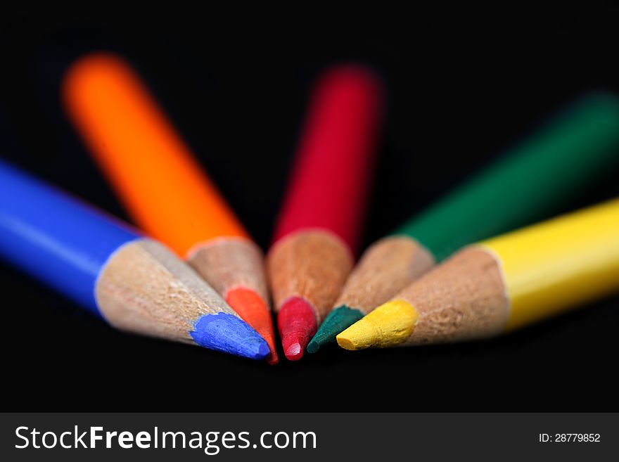 Different colour pencils on a black background