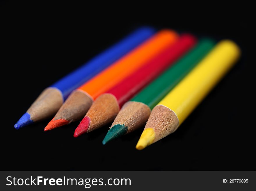Different colour pencils on a black background