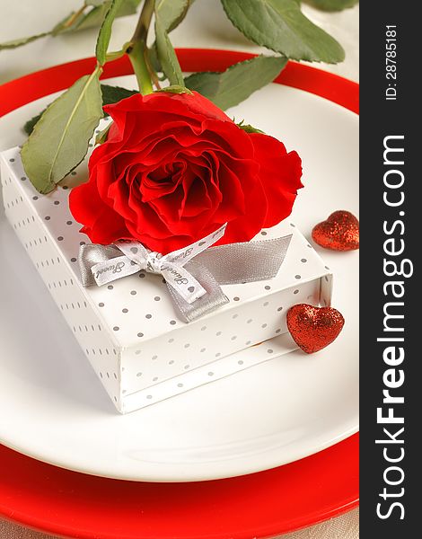 Romantic dinner setting with a rose and gift box. Romantic dinner setting with a rose and gift box