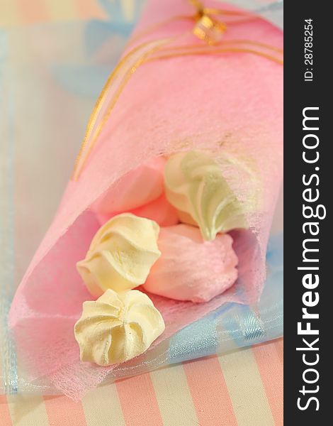 Pastel color meringue cookies in pink fabric package