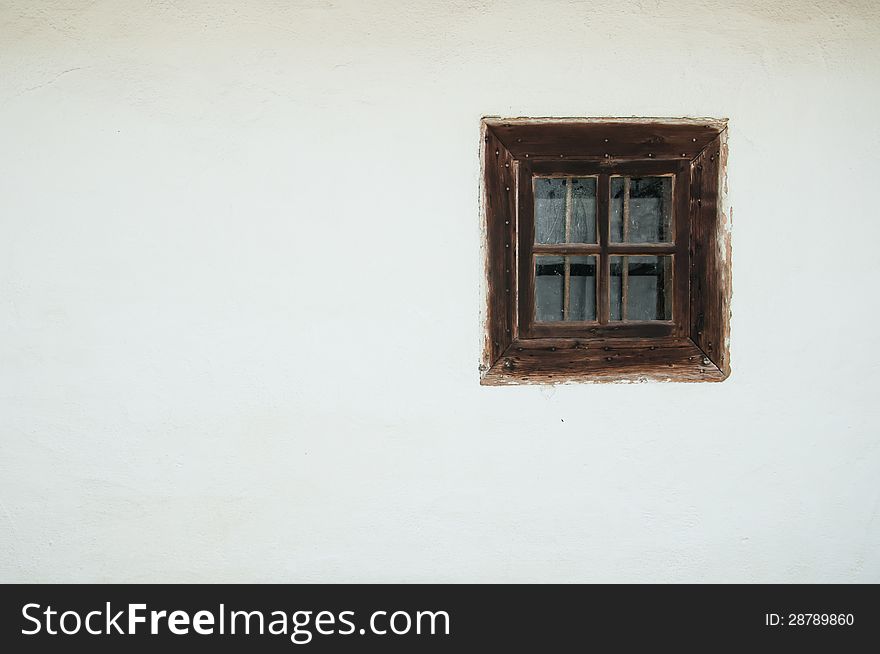 White wall of a rural house with an old wooden window. White wall of a rural house with an old wooden window