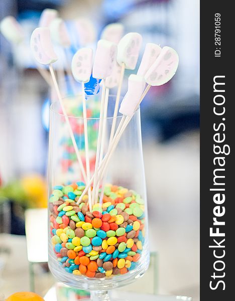Delicious colored candies in a glass and lollipops for an event candy bar. Delicious colored candies in a glass and lollipops for an event candy bar