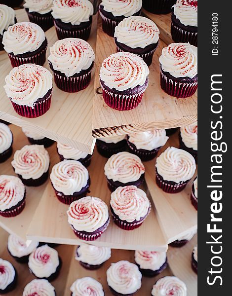 Delicious red velvet cupcakes on a wooden cake stand