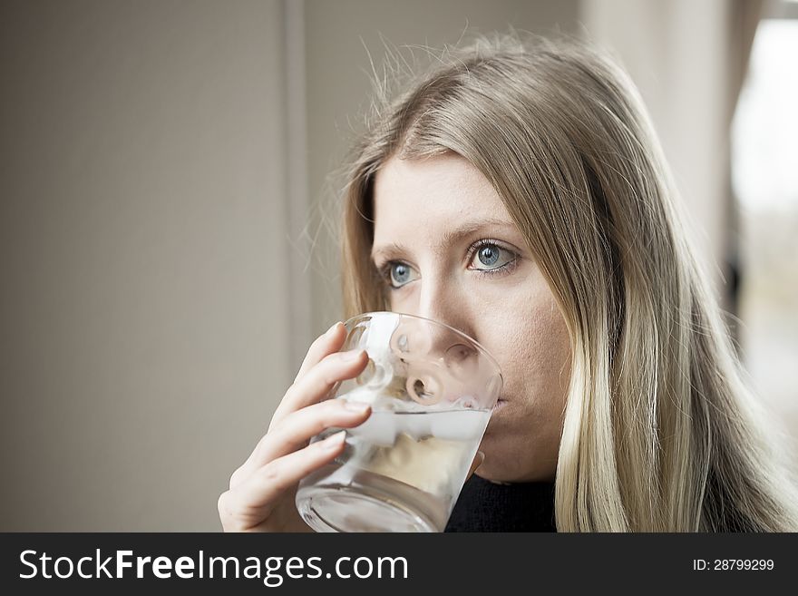 Pretty young blonde woman drinking a glass of water. Pretty young blonde woman drinking a glass of water.