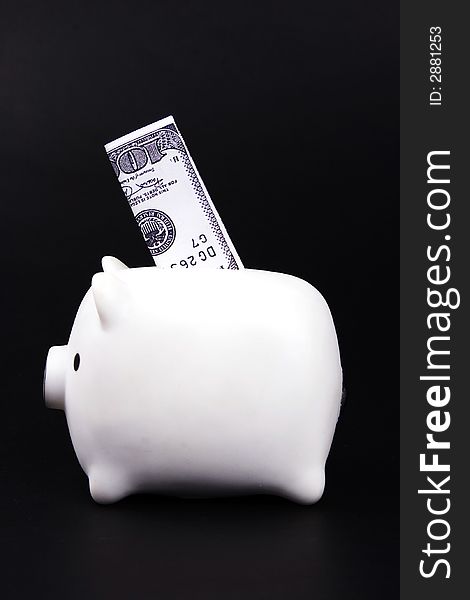 A piggy bank with hundred dollar bill.