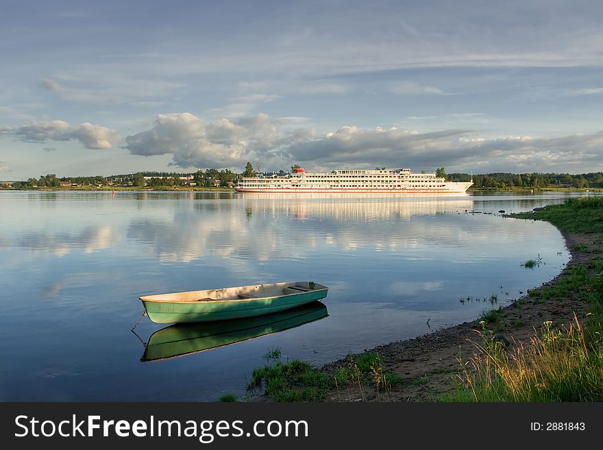 The tourist ship and fishing boat at coast of the river