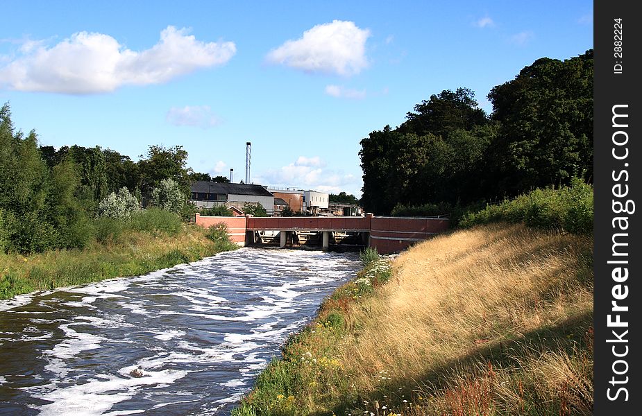 Swollen River with Sluice Gate, Bridge and Factory in the background