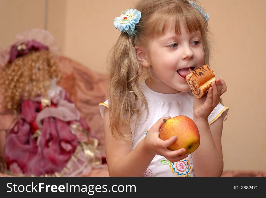 A girl holding an apple and a cake. A girl holding an apple and a cake