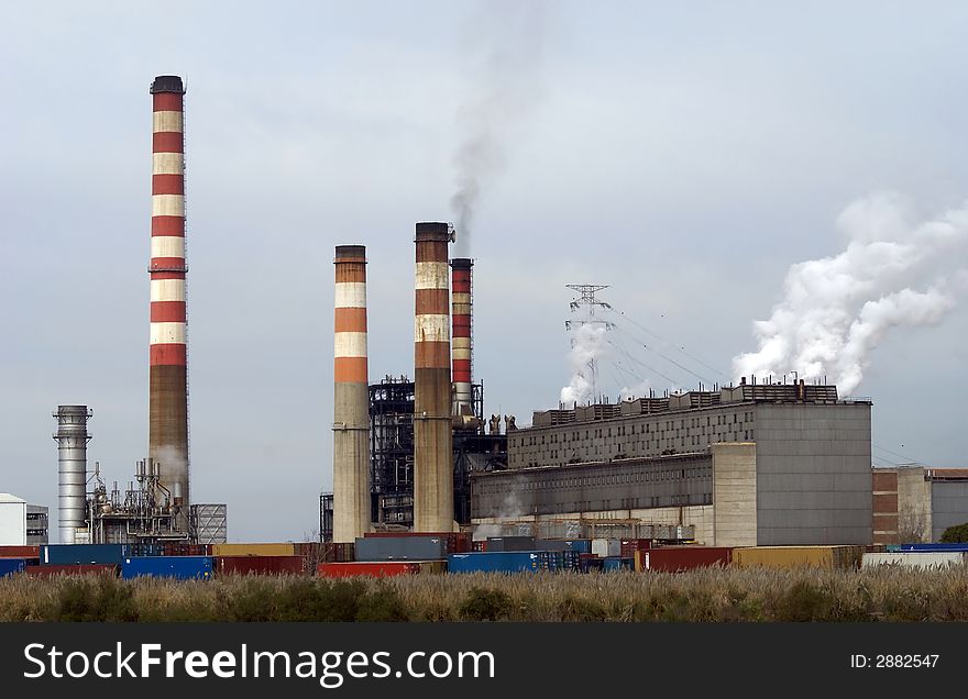 Huge powerplant with tall chimneys polluting the air