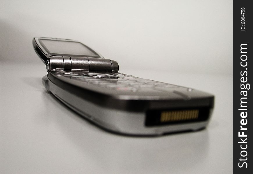 Closed mobile clamshell phone on a neutral background