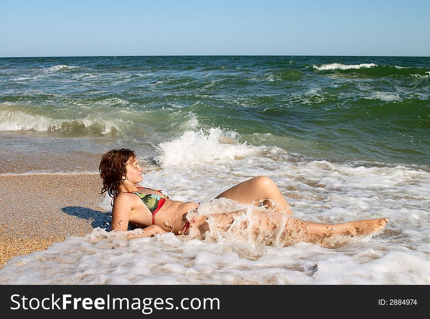 Girl sunburning in surf on the sea coast