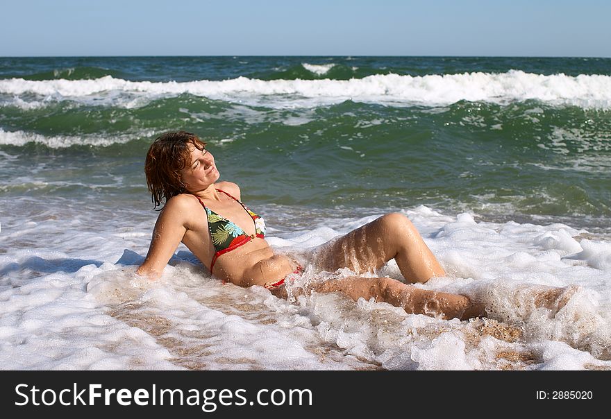 Girl relaxing in wave at the sea coast