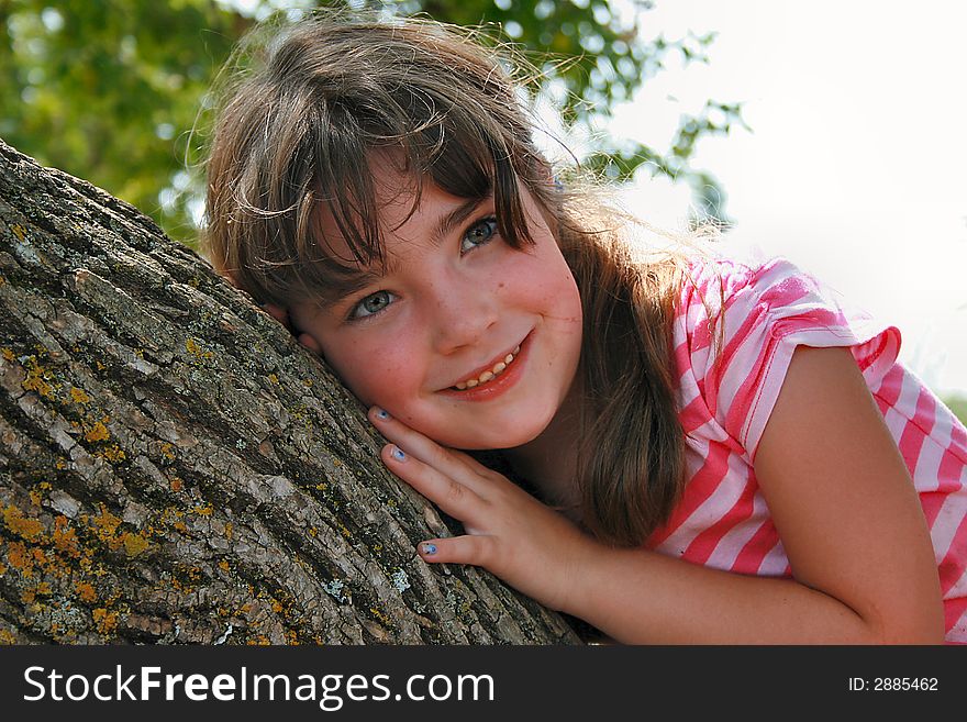 Beautiful little girl in leaning on a tree. Beautiful little girl in leaning on a tree.