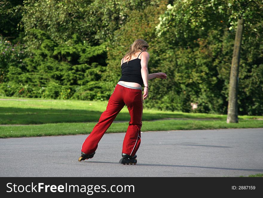 Girl riding on rollerskates in the park. Girl riding on rollerskates in the park