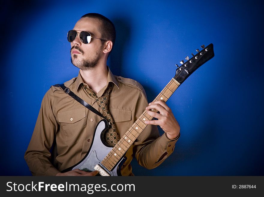 Alternative guitar player in studio, wearing sunglasses. Alternative guitar player in studio, wearing sunglasses.