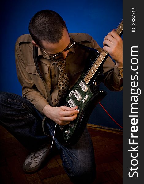 Rocker getting ready to play, tuning his guitar. Rocker getting ready to play, tuning his guitar.