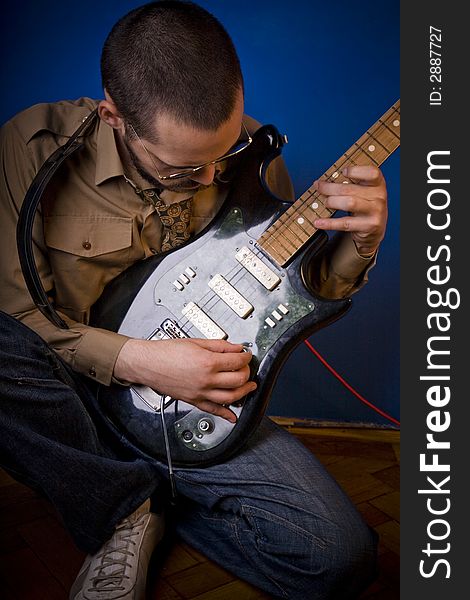 Rocker getting ready to play, tuning his guitar. Rocker getting ready to play, tuning his guitar.